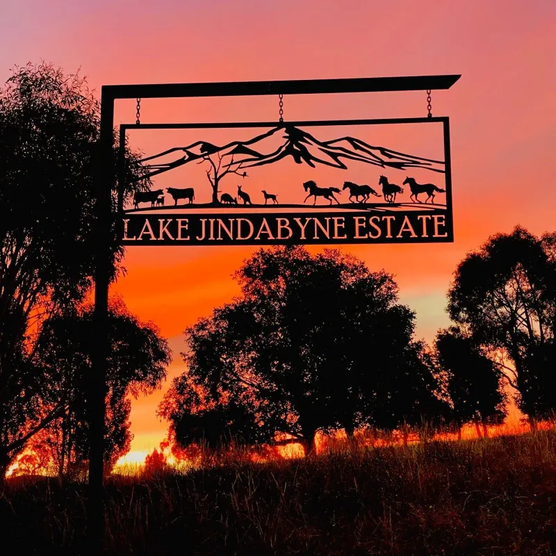 Custom LAKE JINDABYNE ESTATE property sign silhouetted against a sunset